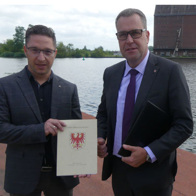 bergabe Frdermittelbescheid Uferweg von Staatssekretr Rainer Genilke (rechts) an Michael Reh als Vertreter der Stadt Eisenhttenstadt im Juni 2020.