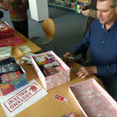 Eisenhüttenstadts Bürgermeister Frank Balzer packt Geschenke für die Aktion "Weihnachten im Schuhkarton"